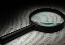 Magnifying glass lying on top of a newspaper
