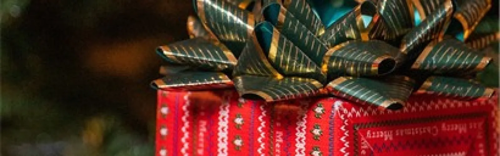 Closeup of a red gift with a green bow.