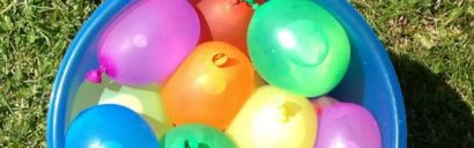 Bucket of colorful water balloons.