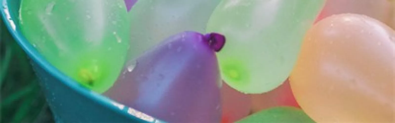 Colorful water balloons in a blue bucket