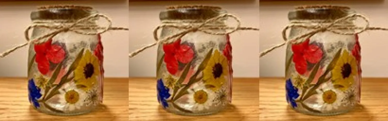 Glass jar decorated with pressed flowers.