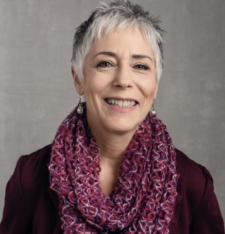 Headshot of author Rebecca Russell, a women with short gray hair and a burgundy scarf.